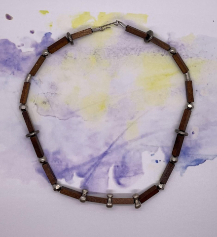 Unisex Choker- Four Sided Wood Beads. Silver Metal Discs. Silver Metal Bicone Beads. Silver Metal Ribbed Tube Beads. Round Silver Metal Beads. Four Cornered Silver Metal Beads. Approx. length: 16 inches. Pronounced: dah-GO-GO Origin: Nigeria Meaning: Rivers