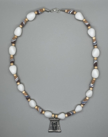 Unisex Neckwear- White Frosted Acrylic Teardrop Beads. Small Natural Wood Beads. Striped Tube Sandcast Glass Beads. 1 inch Pewter Egyptian Engraved Centerpiece. Approx. length: 20 inches. Pronounced: NDU-WU-EE-SEE. Origin: Igbo. Meaning: Life is Supreme