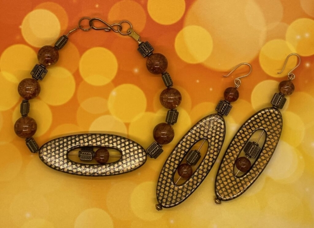 Ankle Bracelet- Smooth Gold Metal Balls. Strip Kente Krobo Beads. Engraved Gold Metal Balls. Leather Strung. Wood Ball Loop Closure. Approx. length: 9 inches. Earrings to Match. Large Green Glass Balls. Leather Strung. Approx. length: 3 inches. 14K Gold Filled Earwire. Pronounced: ee-FEN-ke-lee Origin: Ibo Meaning: Show Thing - Love