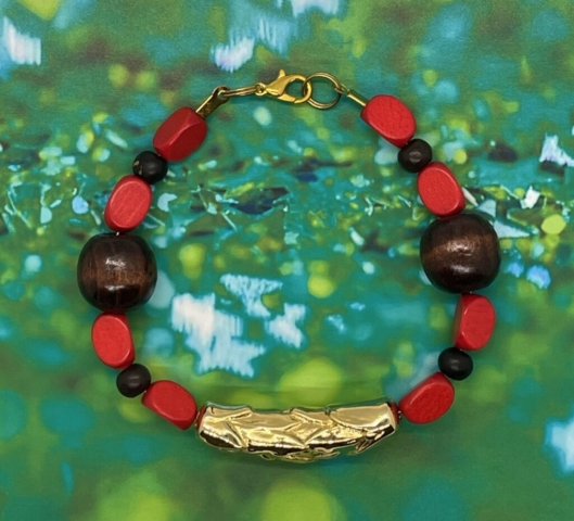 Ankle Bracelet- Three Sided Red Vintage Wood Beads. Brown Rondelle Beads. Polished Round Wood Beads. Gold Metal Leaf Carved Centerpiece. Approx. length: 9 inches. Pronounced: DES-tah Origin: Ethiopia Meaning: Joy or Happiness