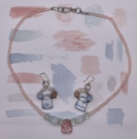 Choker Set- Pink Translucent Pony Beads. Frosted and Clear Round and Oval Acrylic Beads. Pink Acrylic Triangle Centerpiece. Approx. length: 19 inches. Earrings to Match: Pink Translucent Pony Beads. Pink Opaque Square Stones. Blue Opaque Acrylic Round Beads. Translucent Blue Streaked Acrylic Triangle Beads. Approx. length: 1 1/2 inches. .925 Sterling Silver Earwire. Pronounced: Eh-BEH-leh Origin: Igbo Meaning: Kindness