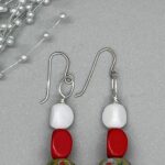 Earrings- 3 Sided White Acrylic Beads. 3 Sided Red Wood Beads. West African Artisan Hand Painted Glass Beads. Yellow Wood Discs. Approx. length: 2 1/2 inches. Hand Shaped .925 Sterling Silver Earwire. Pronounced: Kibibi-KEE-BE-BE. Origin: Africa. Meaning: Little lady