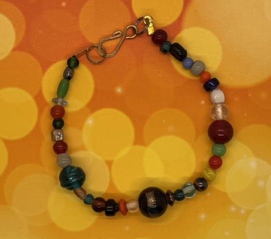 Ankle Bracelet- Glass and Acrylic Mixed Shape, Size and Color Beads. Lamp work Glass Center Bead. Approx. length: 9 1/2inches. Pronounced: mi-REHM-beh Origin: Eastern Africa Meaning: Woman of Peace