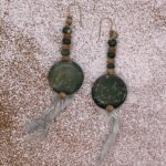 Earrings- Spotted Bicone Wood Beads. Natural Wood Bicone Beads. Spotted Flat Shell Discs. Turquoise Feathered Tassel, Approx. length: 2 1/2 inches. with tassel 4 inches 14K Gold Filled Earwire. Pronounced: ta-SHEE Origin: Hausa Meaning: A Bird of Flight