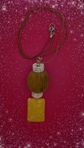 Necklace- Vintage White and Gold Speckled Porcelain Heishi Beads. Large Wood Carved Accent Ball. Vertical Opalescent Yellow Single Sided Domed Center Sparkle Bead. Rawhide Strung. Approx. length: 23 1/2 inches. Pronounced: AH-bay-oh-me. Origin: Yoruba. Meaning: She Brings Me Joy