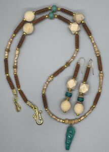 Necklace Set- Carved Brown Acrylic Tube Beads. Small Natural Wood Beads. Natural Wood Bicone Beads. Small Gold Metal Round Beads. Natural Wood Beehive Beads. Faceted Natural Wood Beads. Small Green Swirl Round Clay Beads. 1 1/4 inch Acrylic Green Swirl Elongated Carved Pendant. Approx. length: 27 inches. Hand Shaped 14K Gold Filled Earwire. Approx. length: 3 1/4 inches. Pronounced: BO-LAH-NEE-Lah. Origin: Africa. Meaning: Our Treasure