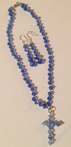 Classic Blue Crystal Set- Dark Sapphire Blue Crystal Bicone Beads. Approx. length: 15 inches. Attached Cross: Light Sapphire Blue Crystal Bicone Beads. Approx. 1 1/2 inches. Earrings to Match. Approx. length 2 inches. .925 Sterling Silver Earwire.