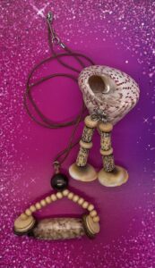 Necklace Set- Acrylic Accent Ball. Natural Rondelle Wood Beads. Beige and Brown Bone Discs. Large Four Sided Speckled Polished, Wood Center Bead. Leather Strung. Approx. length: 21 inches. 3 inch Earrings to Match. Small Rondelle Disc Beads. Betel Nut Tube Beads. Polished Shiva Shells. .925 Sterling Silver Earwire. Pronounced: FOLA-mee. Origin: Yoruba. Meaning: Respect and Honor Me